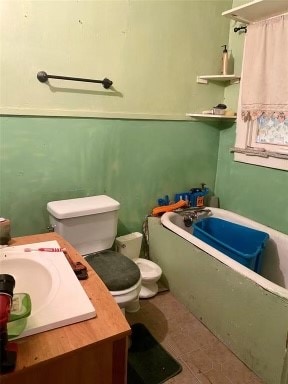 bathroom featuring a washtub, tile flooring, toilet, and vanity