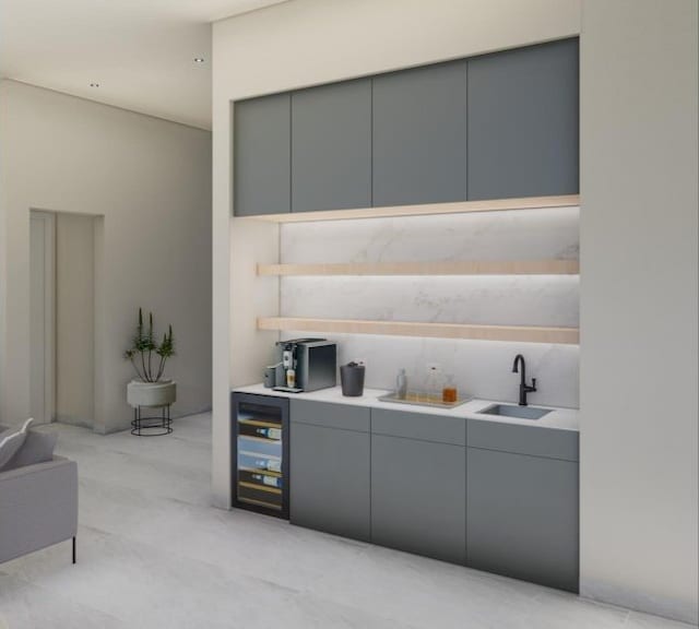 interior space with gray cabinets, beverage cooler, and sink