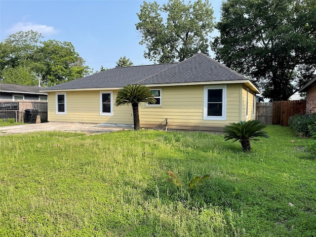 rear view of house with a patio and a lawn