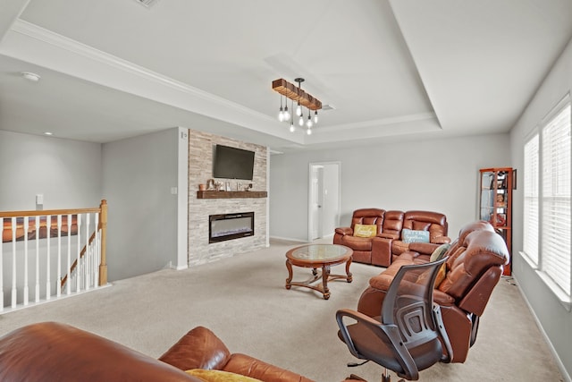 carpeted living room with crown molding, a raised ceiling, and a fireplace