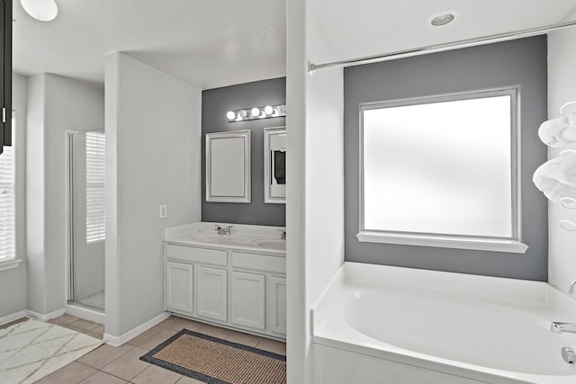 bathroom with tile floors, a wealth of natural light, and vanity