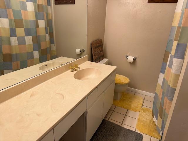 bathroom featuring tile floors, vanity with extensive cabinet space, and toilet