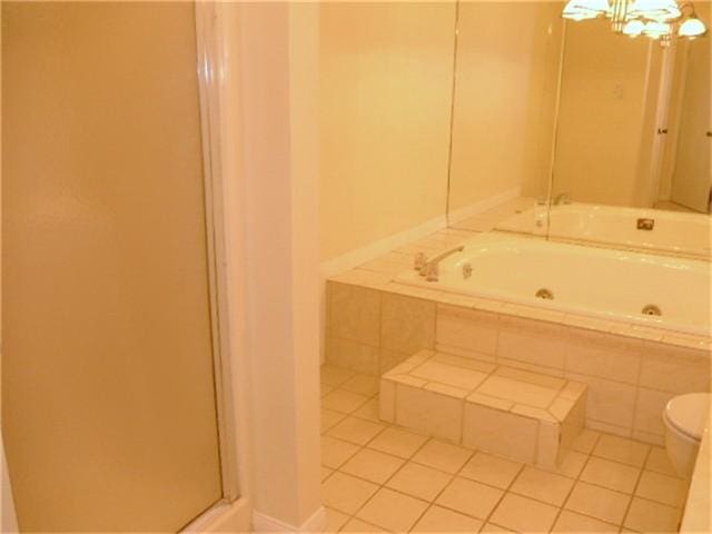 bathroom featuring tile flooring, independent shower and bath, and toilet