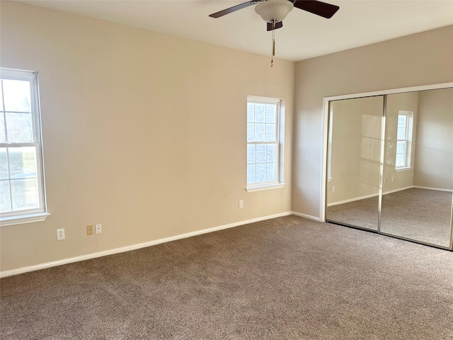 unfurnished bedroom featuring carpet, a closet, and ceiling fan