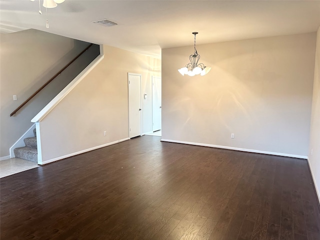 unfurnished living room featuring hardwood / wood-style flooring and ceiling fan with notable chandelier