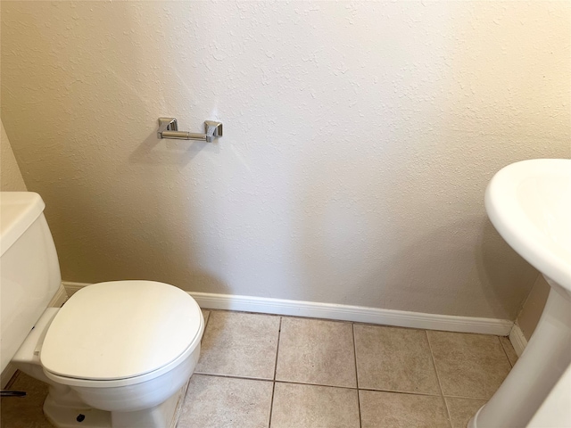 bathroom with tile flooring and toilet