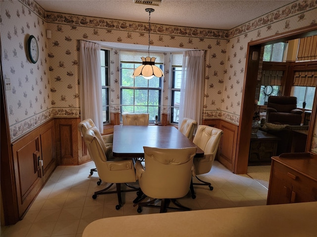 tiled dining room with a textured ceiling