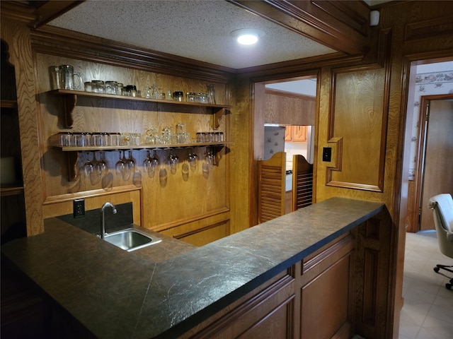 bar with sink, a textured ceiling, and light tile flooring