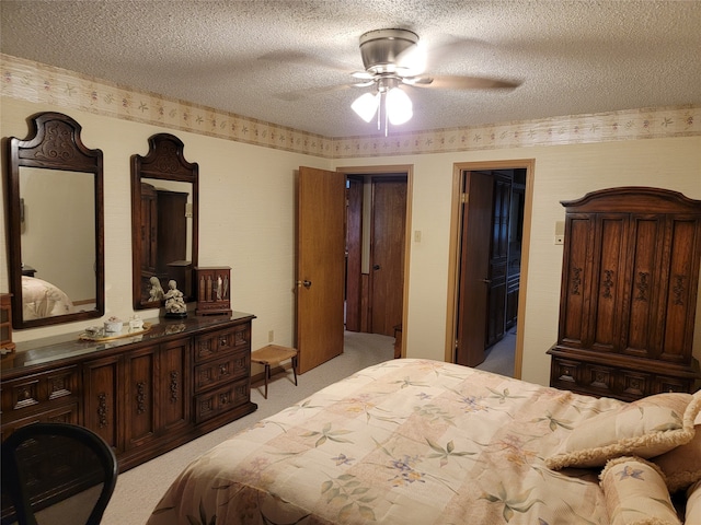 carpeted bedroom featuring a textured ceiling and ceiling fan