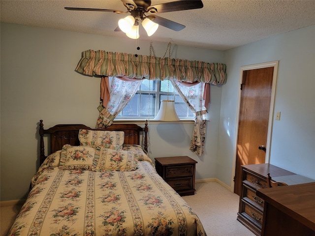 carpeted bedroom featuring ceiling fan and a textured ceiling