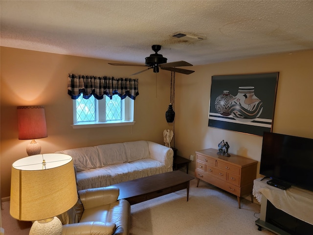 living room featuring a textured ceiling, carpet, and ceiling fan