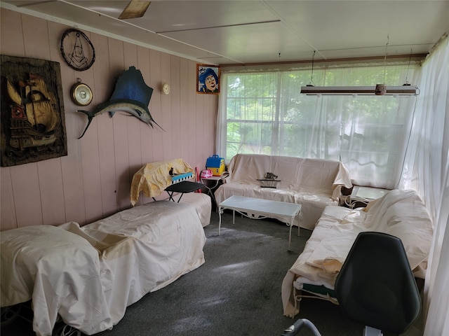 living room featuring carpet and wood walls