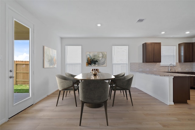 dining area featuring a wealth of natural light, sink, and light hardwood / wood-style floors