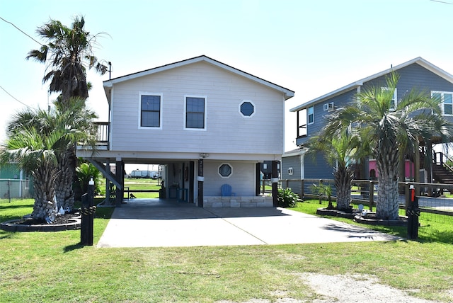 coastal home featuring a carport and a front lawn