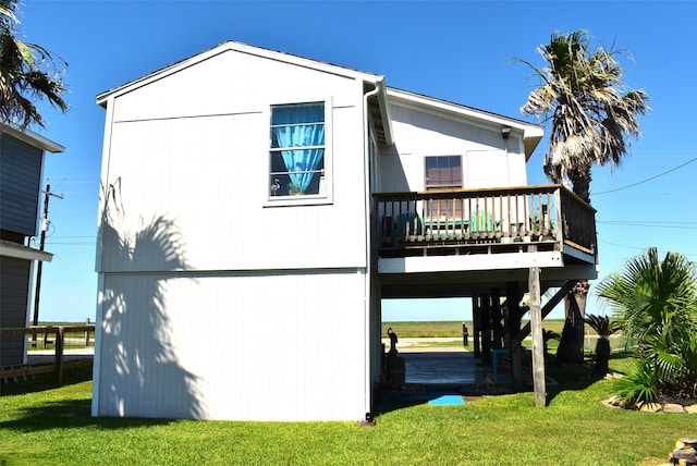 rear view of property featuring a wooden deck and a yard