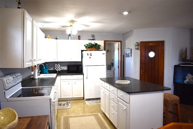 kitchen featuring ceiling fan, a center island, white cabinets, sink, and white appliances