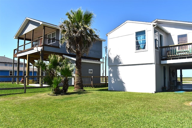 rear view of property with a lawn and a balcony