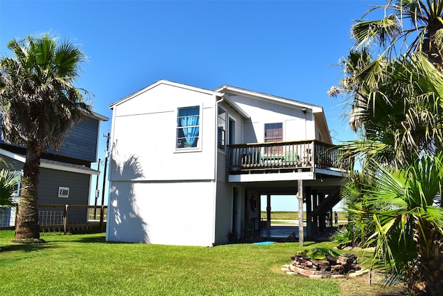 back of property with a wooden deck and a yard