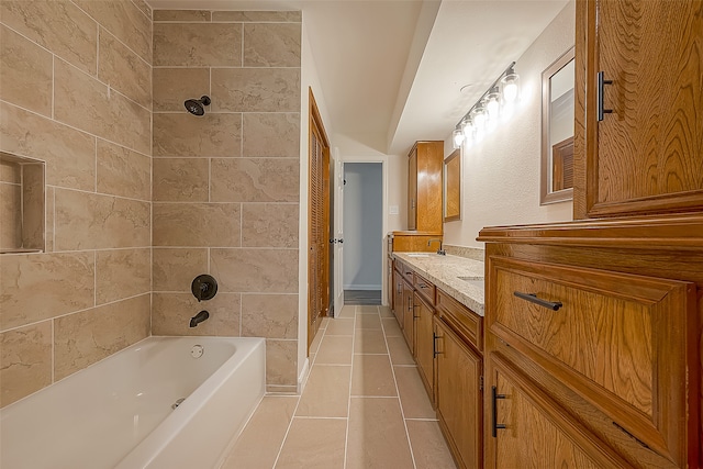 bathroom featuring tile flooring, vanity, and tiled shower / bath