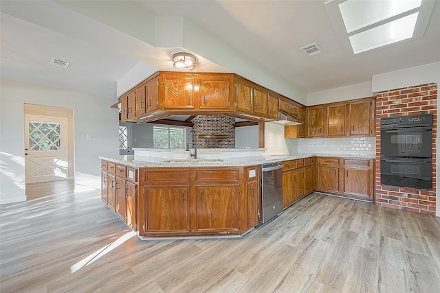 kitchen with double oven, light hardwood / wood-style floors, backsplash, fume extractor, and sink