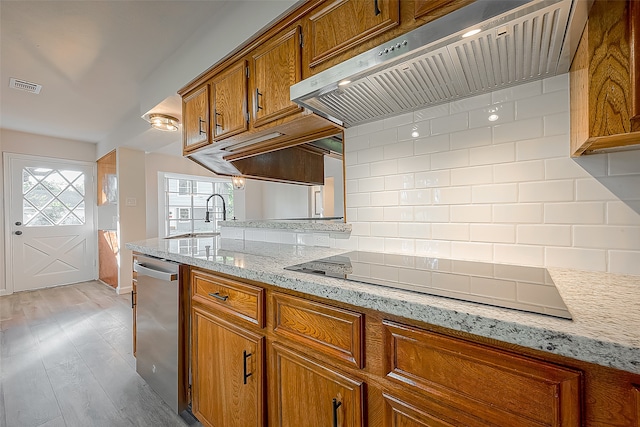 kitchen with light stone counters, light hardwood / wood-style flooring, dishwasher, tasteful backsplash, and black electric cooktop