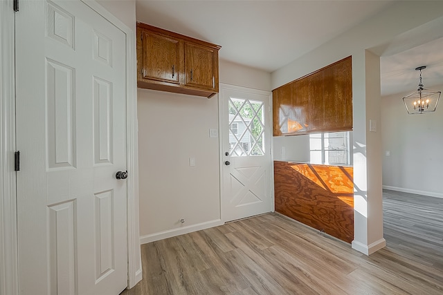 foyer entrance featuring a notable chandelier and light hardwood / wood-style flooring