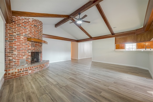 unfurnished living room featuring ceiling fan, light hardwood / wood-style floors, vaulted ceiling with beams, and a fireplace