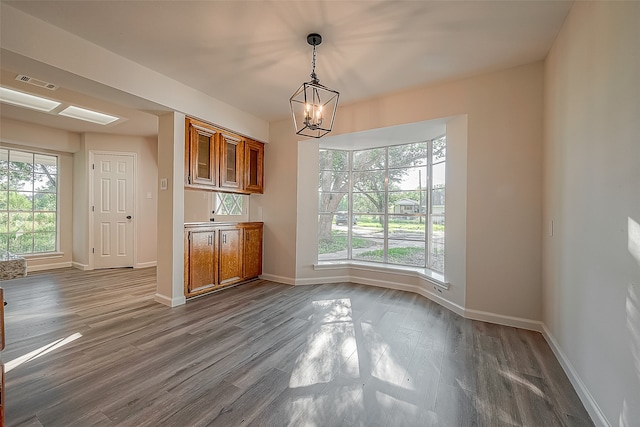 interior space with an inviting chandelier, decorative light fixtures, and dark wood-type flooring