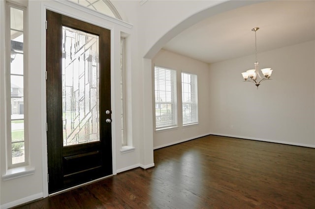 foyer featuring a healthy amount of sunlight, an inviting chandelier, and dark hardwood / wood-style floors