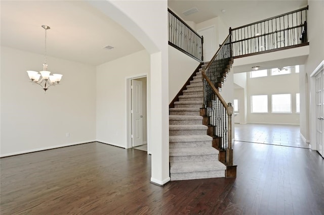 entrance foyer featuring a high ceiling, dark hardwood / wood-style flooring, and an inviting chandelier