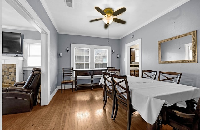 dining area with hardwood / wood-style floors, crown molding, and plenty of natural light