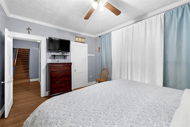 bedroom with hardwood / wood-style flooring, crown molding, and ceiling fan