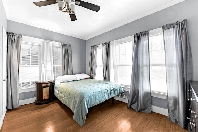 bedroom featuring hardwood / wood-style flooring, ceiling fan, and crown molding