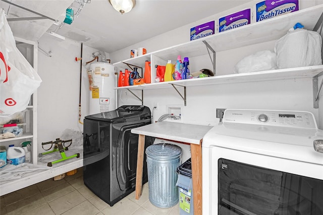 washroom with washing machine and clothes dryer, light tile patterned floors, and gas water heater