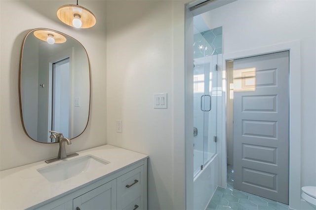 full bathroom featuring combined bath / shower with glass door, vanity, toilet, and tile floors