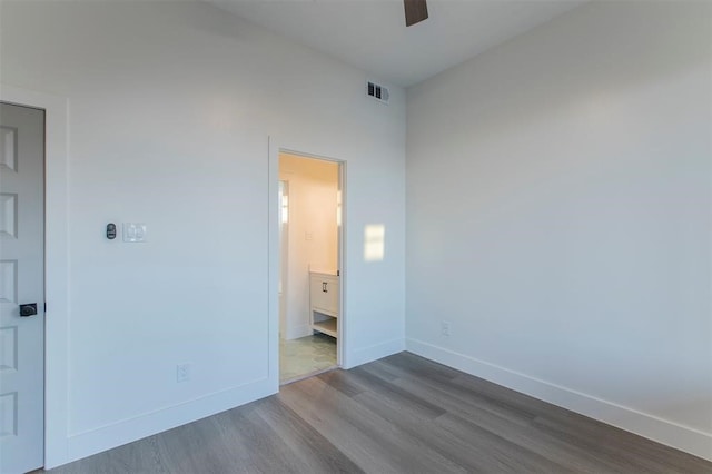 unfurnished bedroom featuring ceiling fan, connected bathroom, and hardwood / wood-style flooring