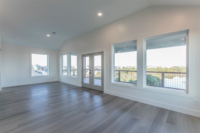 unfurnished room with french doors, dark wood-type flooring, plenty of natural light, and vaulted ceiling