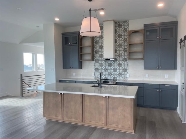 kitchen with dark hardwood / wood-style flooring, lofted ceiling, tasteful backsplash, and a kitchen island with sink