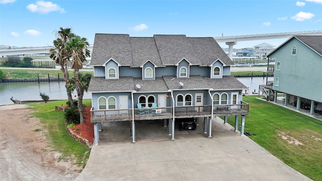 view of front of property featuring a front yard, a carport, and a water view