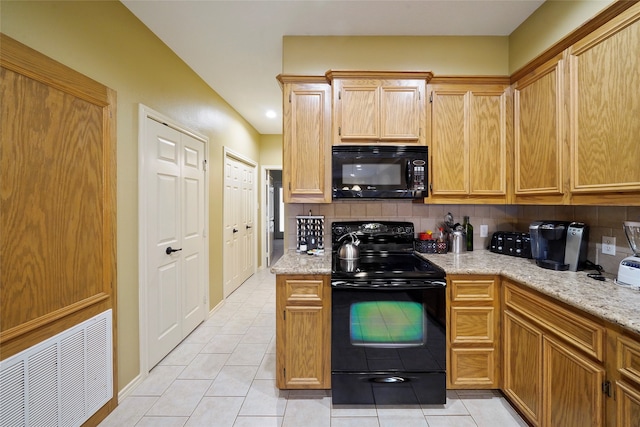 kitchen with light tile floors, black appliances, tasteful backsplash, and light stone counters