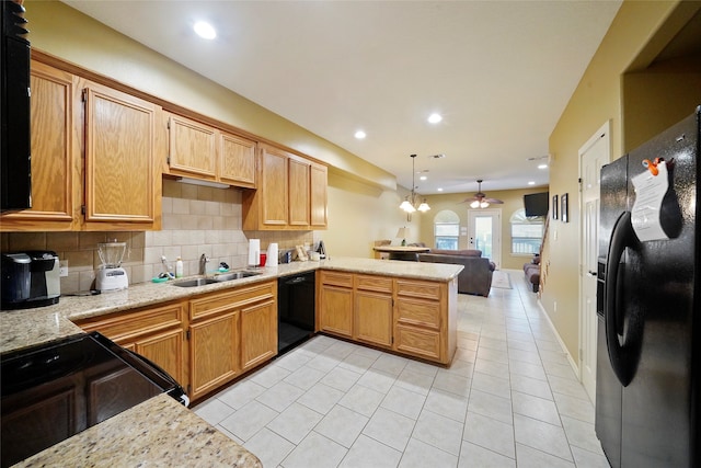 kitchen featuring kitchen peninsula, tasteful backsplash, light tile flooring, pendant lighting, and black appliances