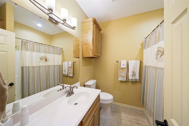 bathroom with tile floors, vanity, and toilet