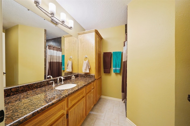 bathroom with tile floors, a textured ceiling, and large vanity