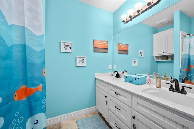 bathroom featuring tile flooring, large vanity, and dual sinks