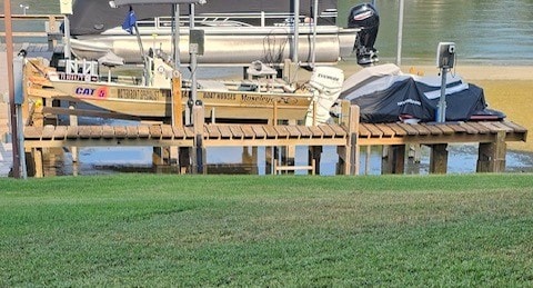 dock area with a lawn and a water view