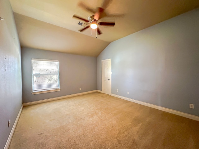 carpeted empty room with ceiling fan and lofted ceiling