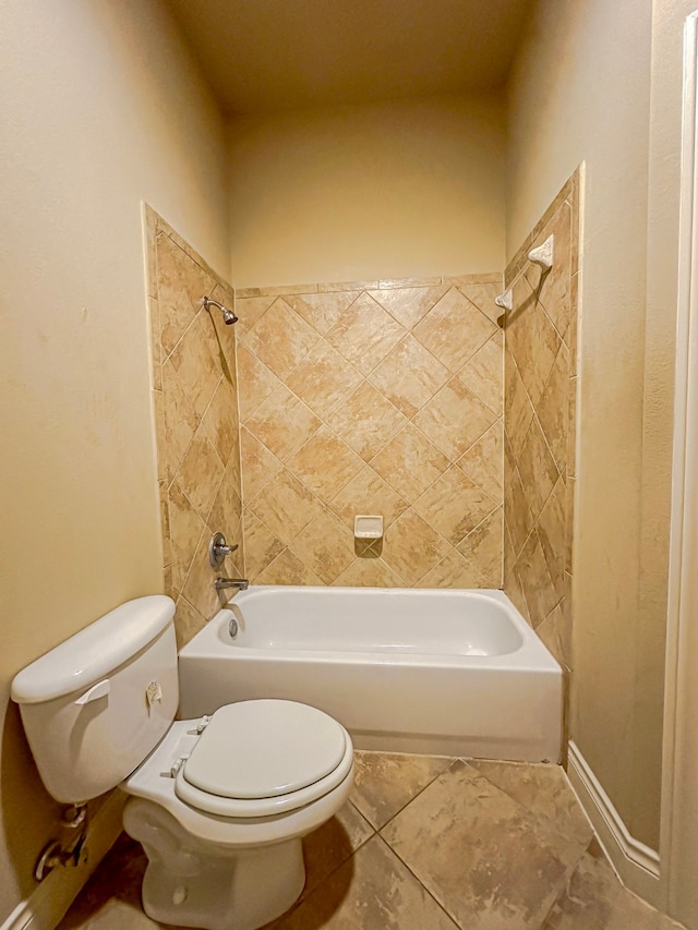 bathroom featuring tile floors, toilet, and tiled shower / bath combo