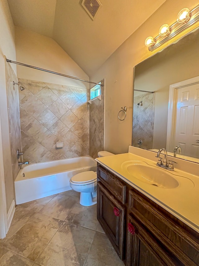 full bathroom with vaulted ceiling, tiled shower / bath combo, tile floors, toilet, and vanity