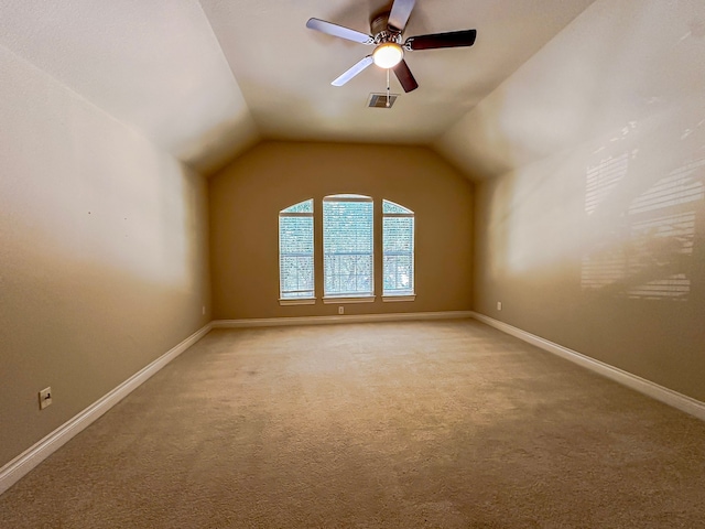 carpeted spare room featuring ceiling fan and lofted ceiling