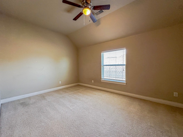 carpeted spare room featuring vaulted ceiling and ceiling fan